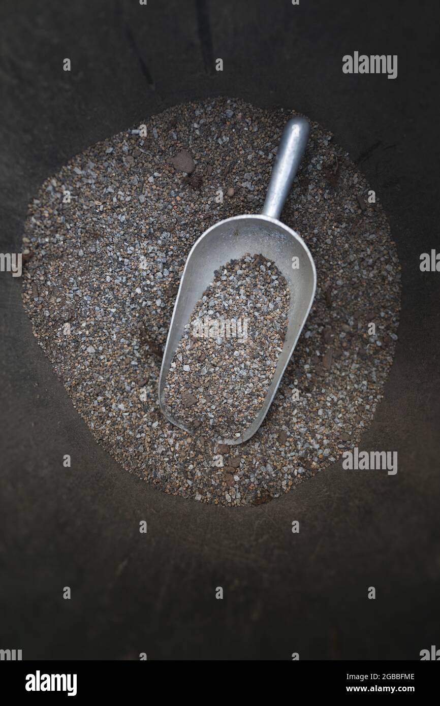 Gravel in bucket with hand shovel measure at garden centre Stock Photo