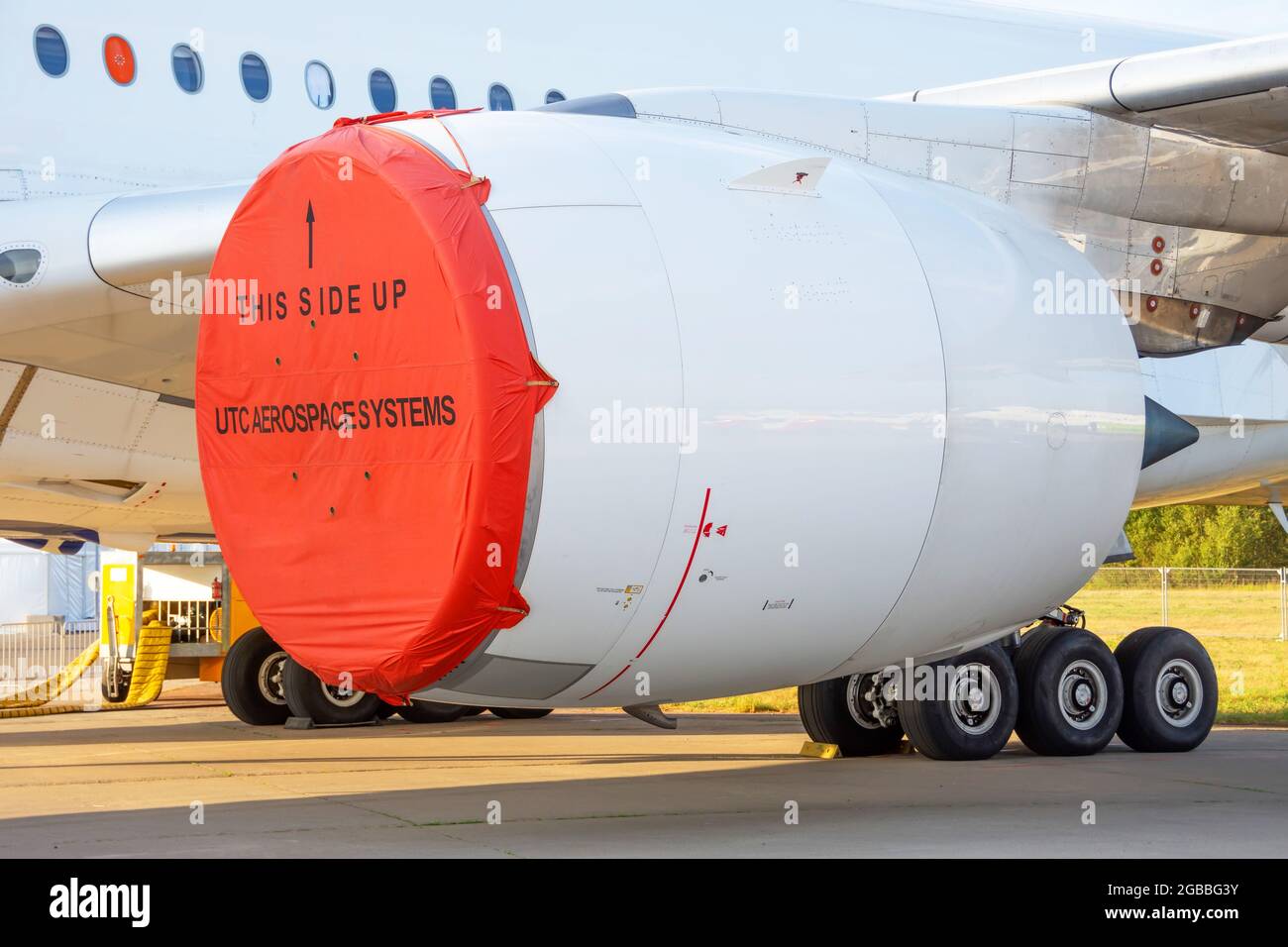 Test aircraft with a red cover on the engine under the wing in a parking lot Stock Photo