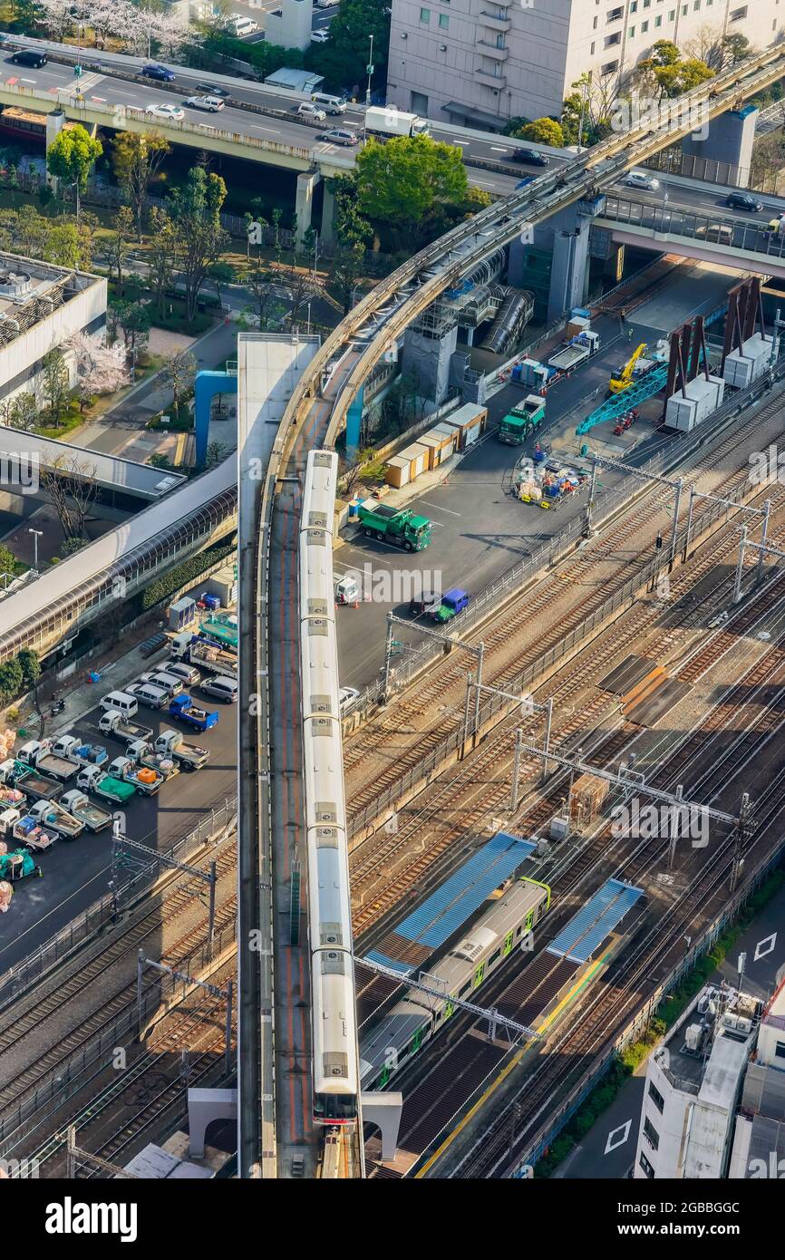 tokyo, japan - april 25 2021: Bird's-eye view of a Yamanote Line train on the tracks of the Hamamatsucho Station overlooked by the aerial Tokyo Monora Stock Photo