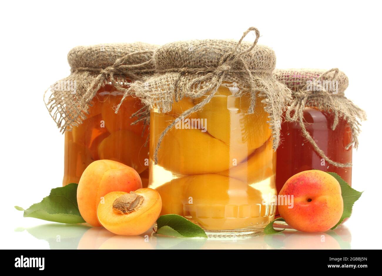 canned apricots and jam in a jars with sweet apricots isolated on white