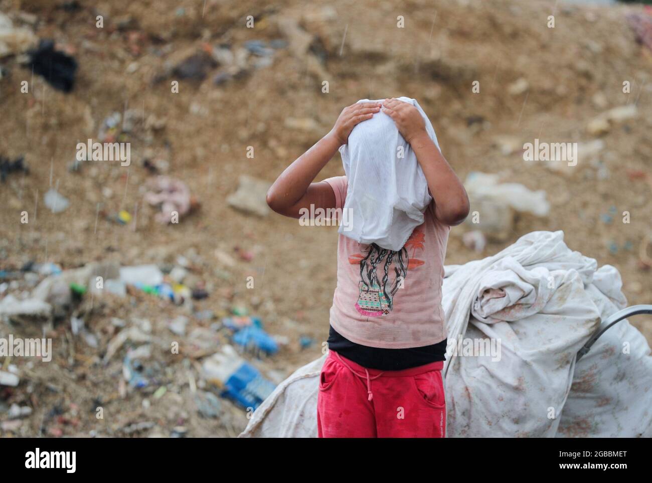 A Tunisian girl, Fatima Ghewili, 9, wears her shirt in Tunis, Tunisia July 31, 2021. Picture taken July 31, 2021. REUTERS/Ammar Awad Stock Photo