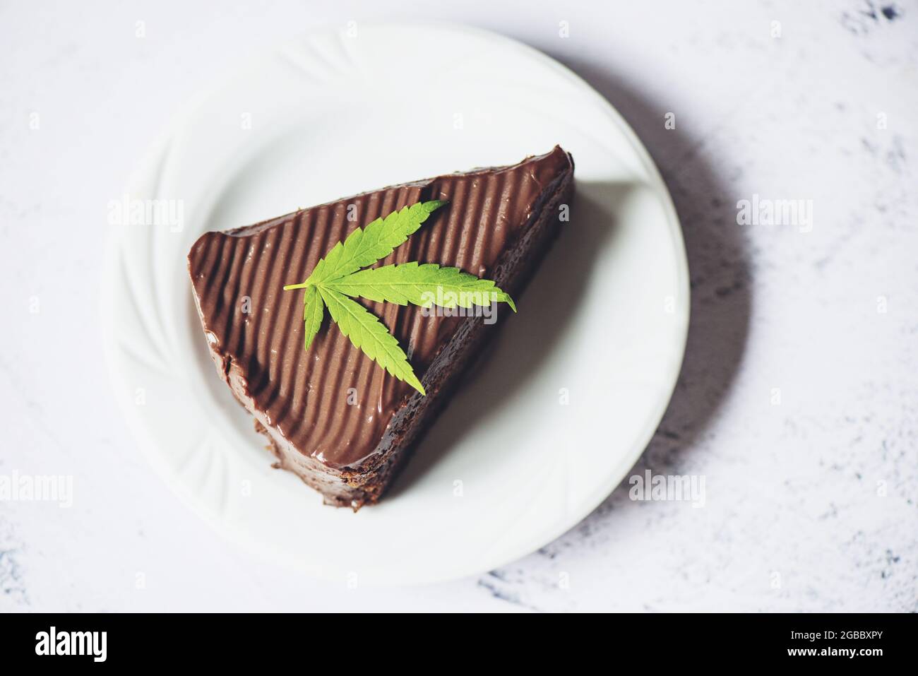 Chocolate cake with cannabis leaf marijuana leaves plant on white