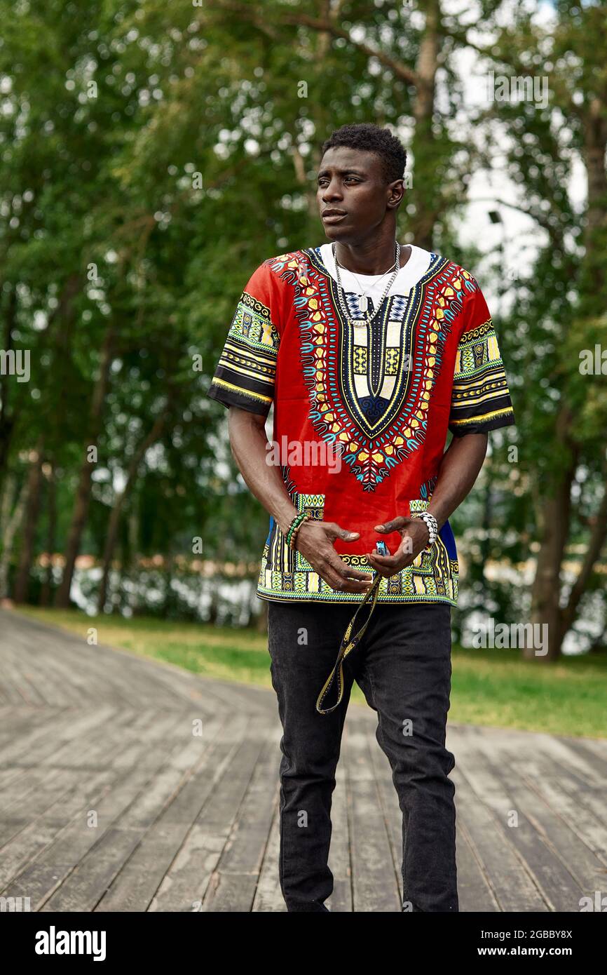 An African man in South African national clothes, a black young man resting in a park in national clothes Stock Photo