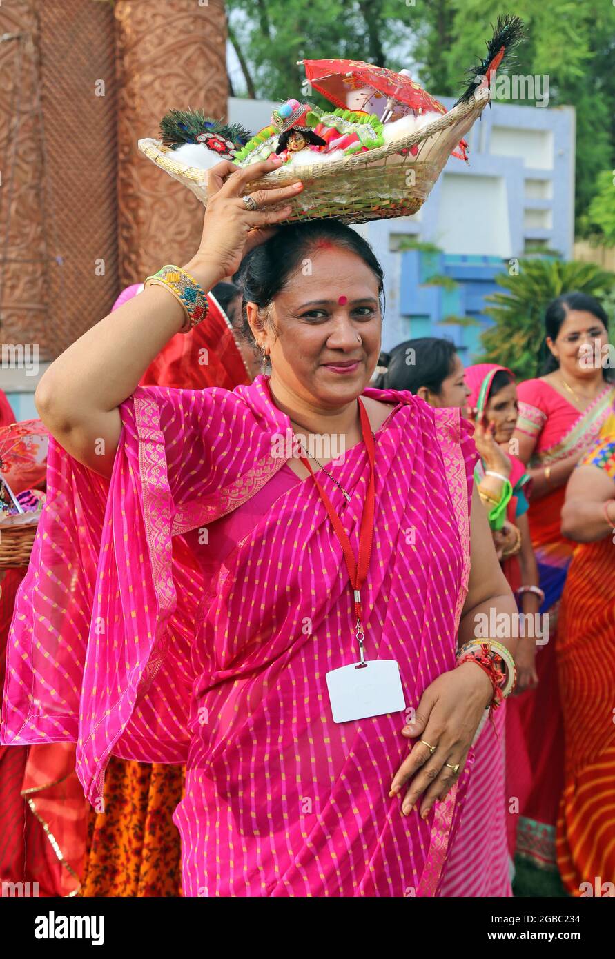 Beawar, Rajasthan, India, August 2, 2021: Hindu woman carrying the idol of Laddu Gopal (Lord Krishna), pose for a picture as she celebrate the holy month of Sawan (Shravan) in Beawar. Photo: Sumit Saraswat Stock Photo