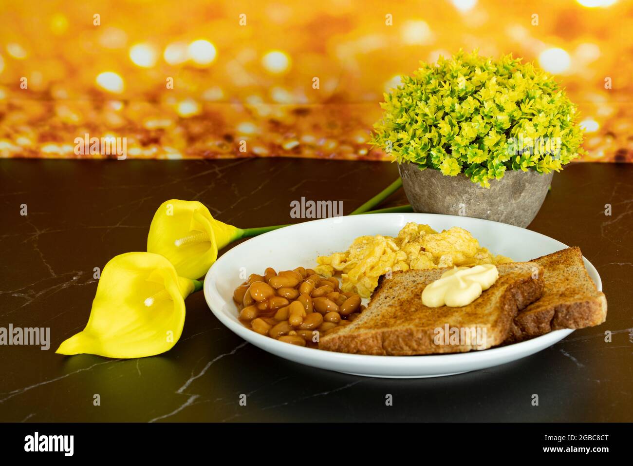 A serving of healthy breakfast with toasted bread, butter, baked beans