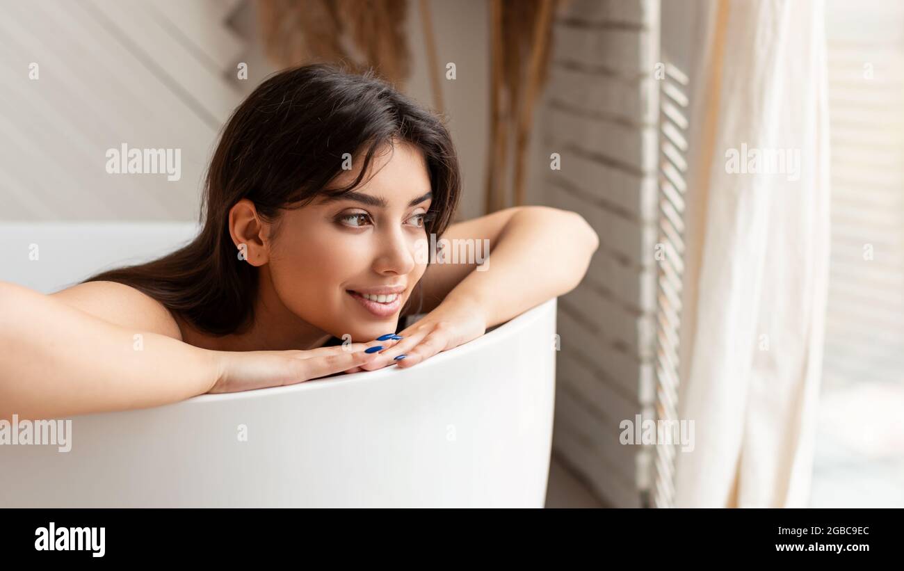 Relaxed Young Lady Taking Bath Lying In Bathtub In Bathroom Stock Photo