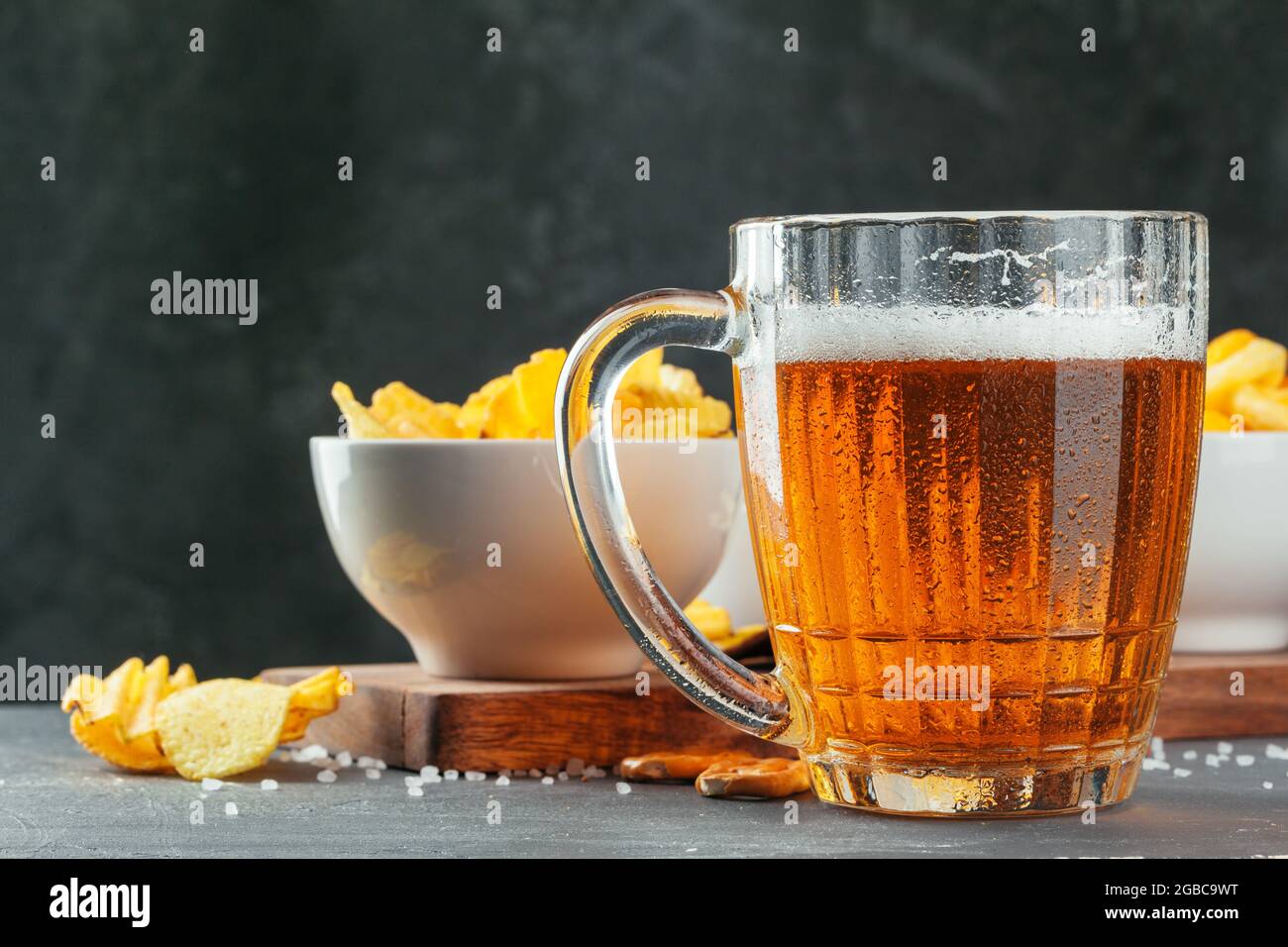 Lager beer and snacks on stone table. Cracker, chips side view Stock Photo