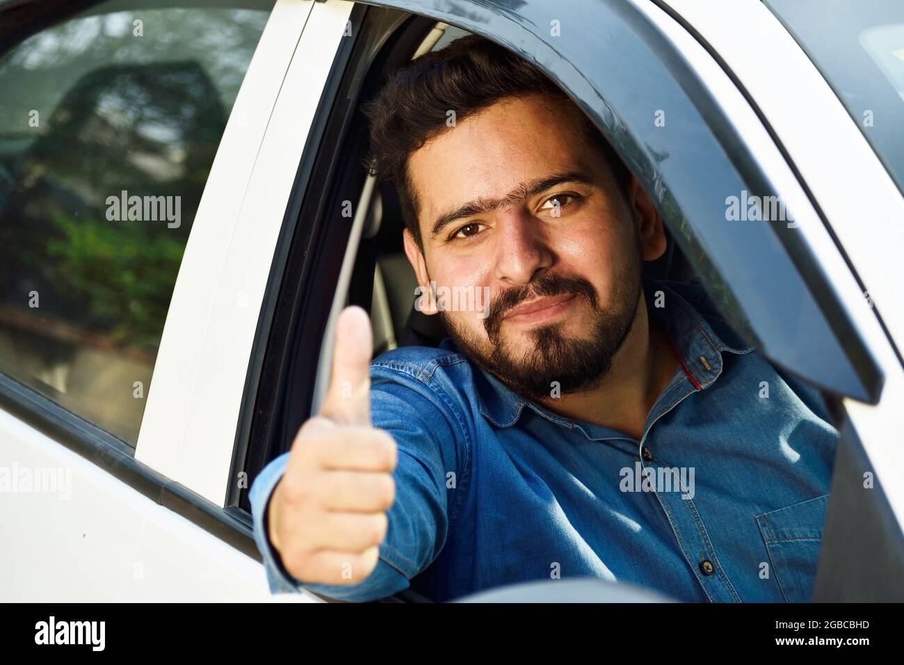 Indian car drive showing thumps up form car's open window Stock Photo
