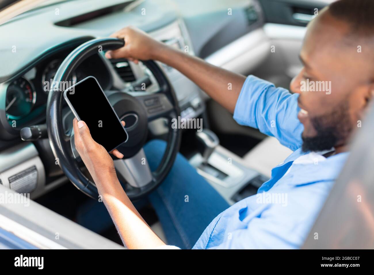 Happy black man using showing smartphone with empty screen Stock Photo