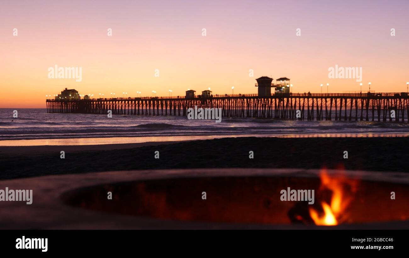 Campfire pit by Oceanside pier, California USA. Camp fire burning on