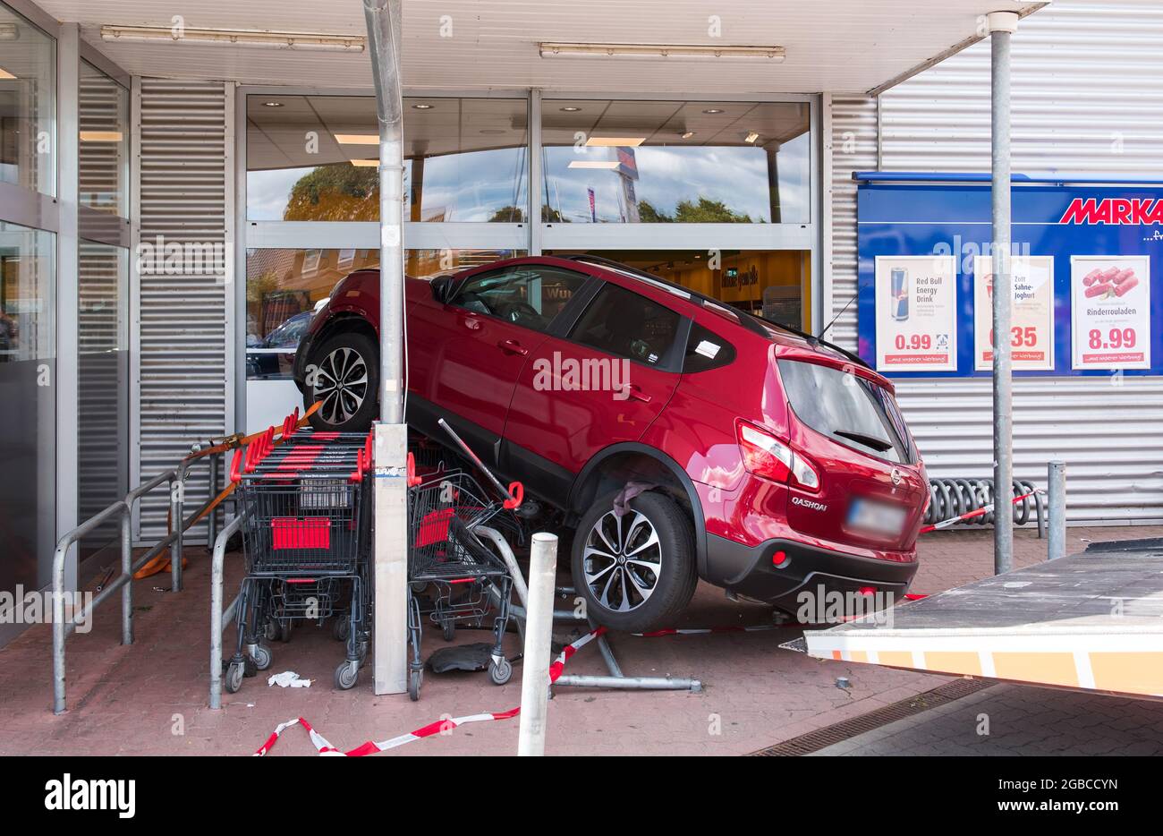 03 August 2021, Schleswig-Holstein, Bredstedt: A car is on shopping carts after a traffic accident in front of a supermarket. An elderly man lost control of his car at noon and came to a halt on shopping carts in front of the discount store, no one was injured. Photo: Daniel Bockwoldt/dpa Stock Photo