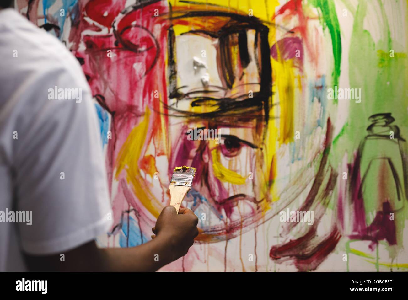African american male painter at work painting on canvas in art studio Stock Photo