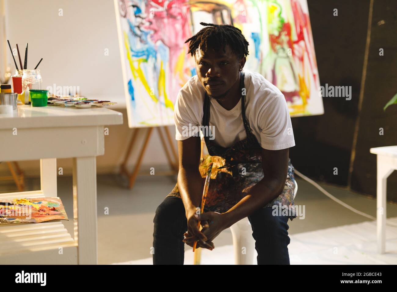 Portrait of african american male painter at work looking at camera in art studio Stock Photo