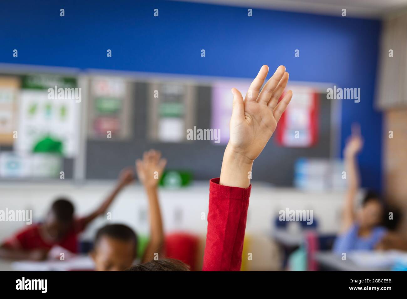 Raised hand of caucasian boy for participation in the class at elementary school Stock Photo