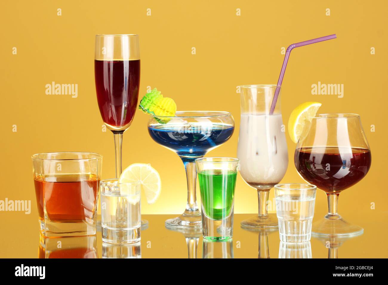 a variety of alcoholic drinks on yellow background Stock Photo Alamy