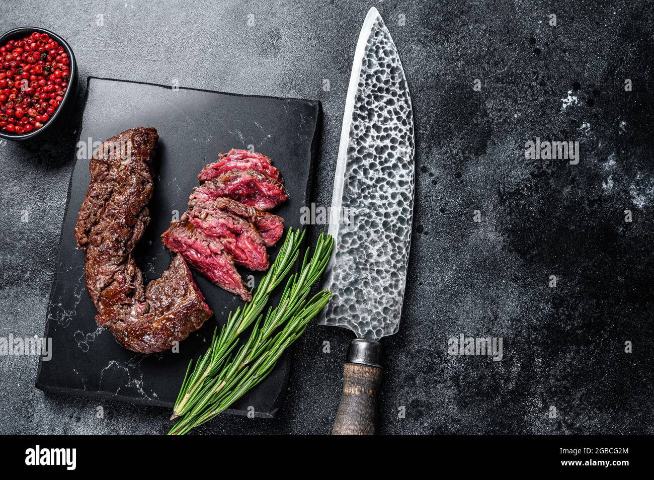 Sliced grilled Onglet Hanging Tender steak on a marble board. Black background. Top view. Copy space Stock Photo