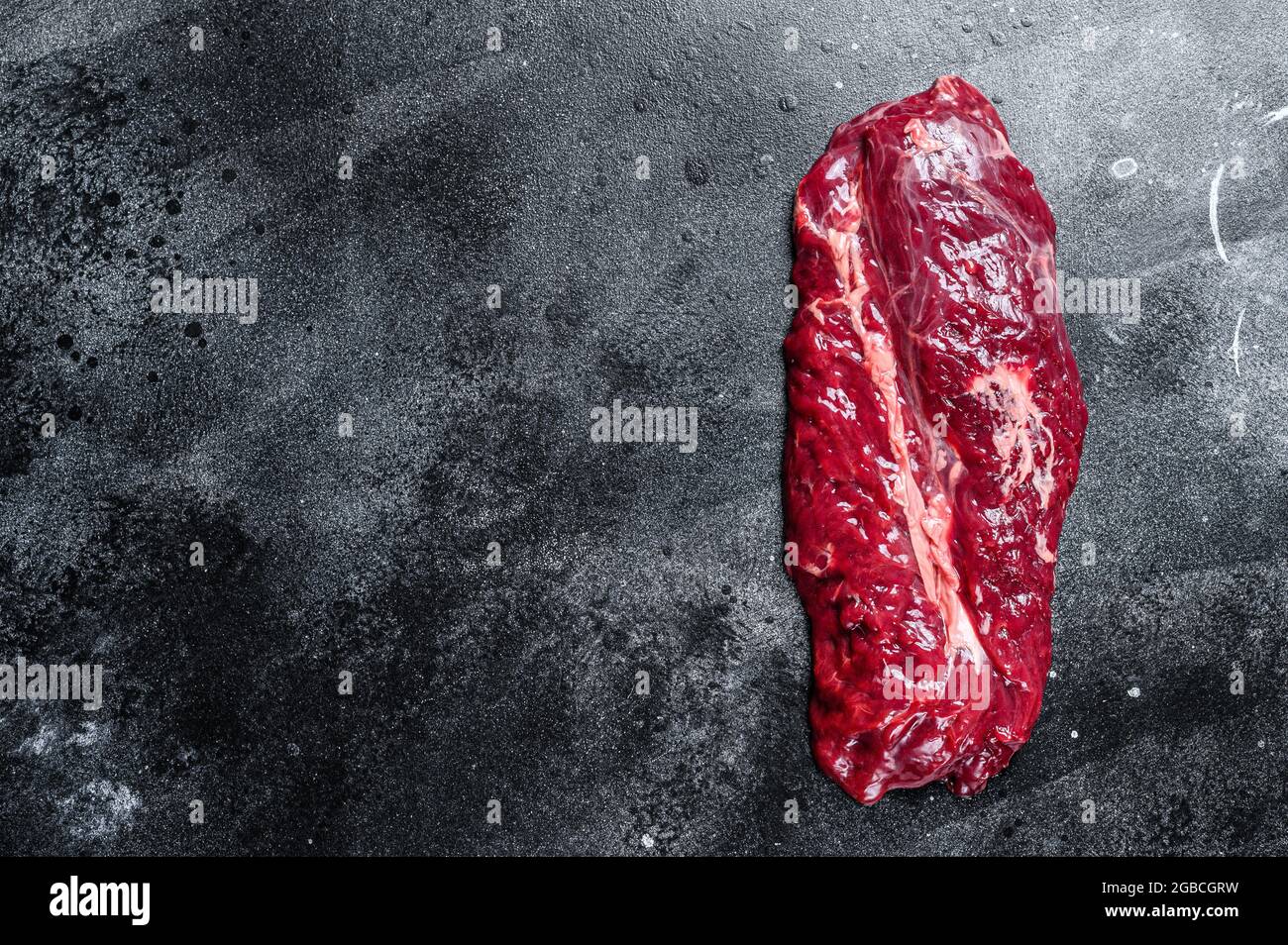 Raw Hanging Tender beef meat steak. Black background. Top view. Copy space Stock Photo