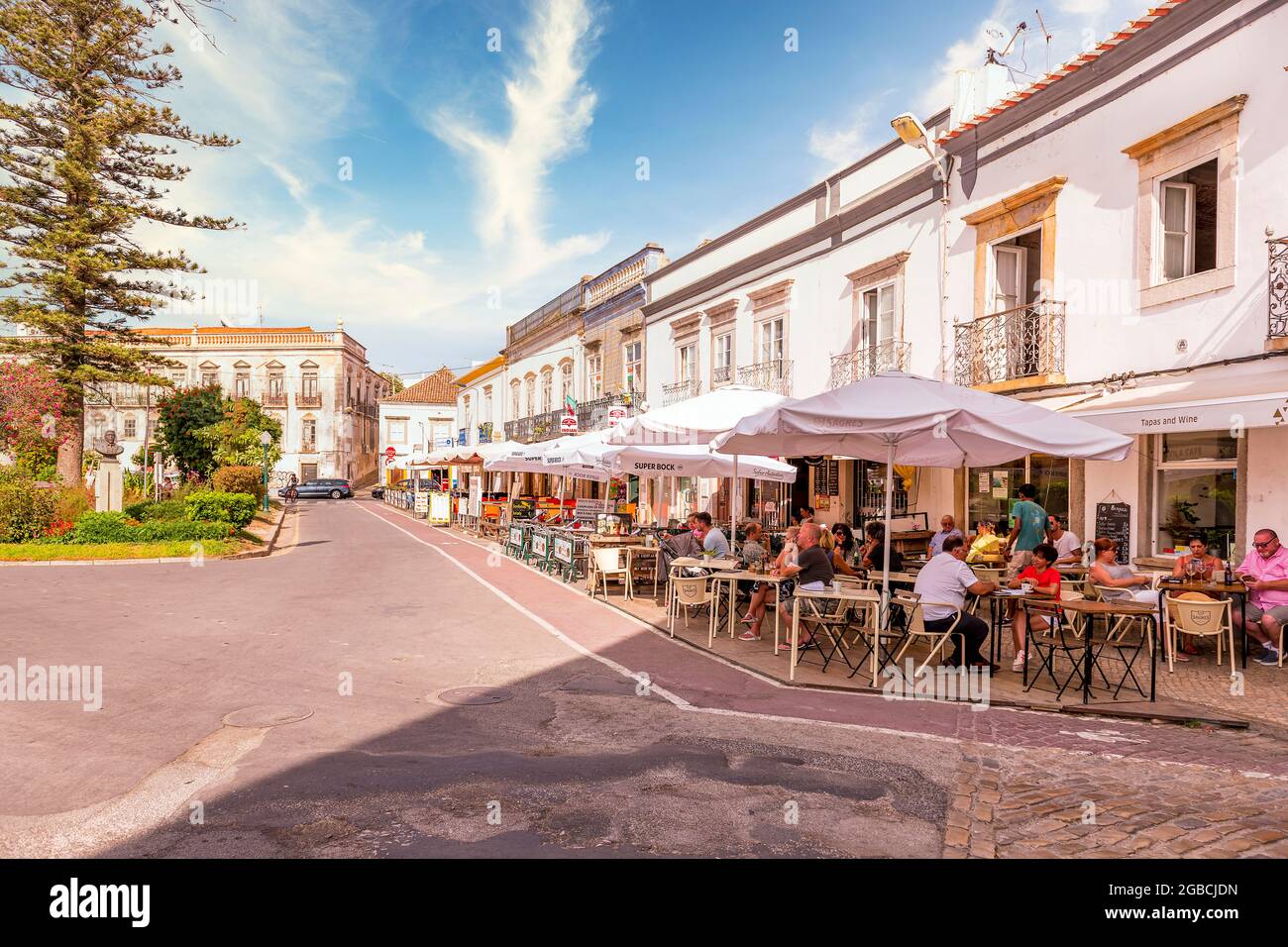 Pavement and streetside cafes and restaurants around the Jardim da Alagoa along Praca Dr. Antonio Padinha Tavira East Algarve Portugal Stock Photo
