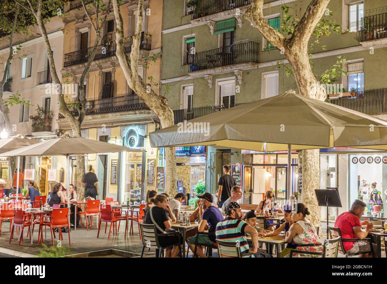 Spain Barcelona Catalonia Catalunya,Rambla de Poblenou pedestrian promenade,tapas restaurant cafe al fresco dining drinking umbrellas tables,night eve Stock Photo