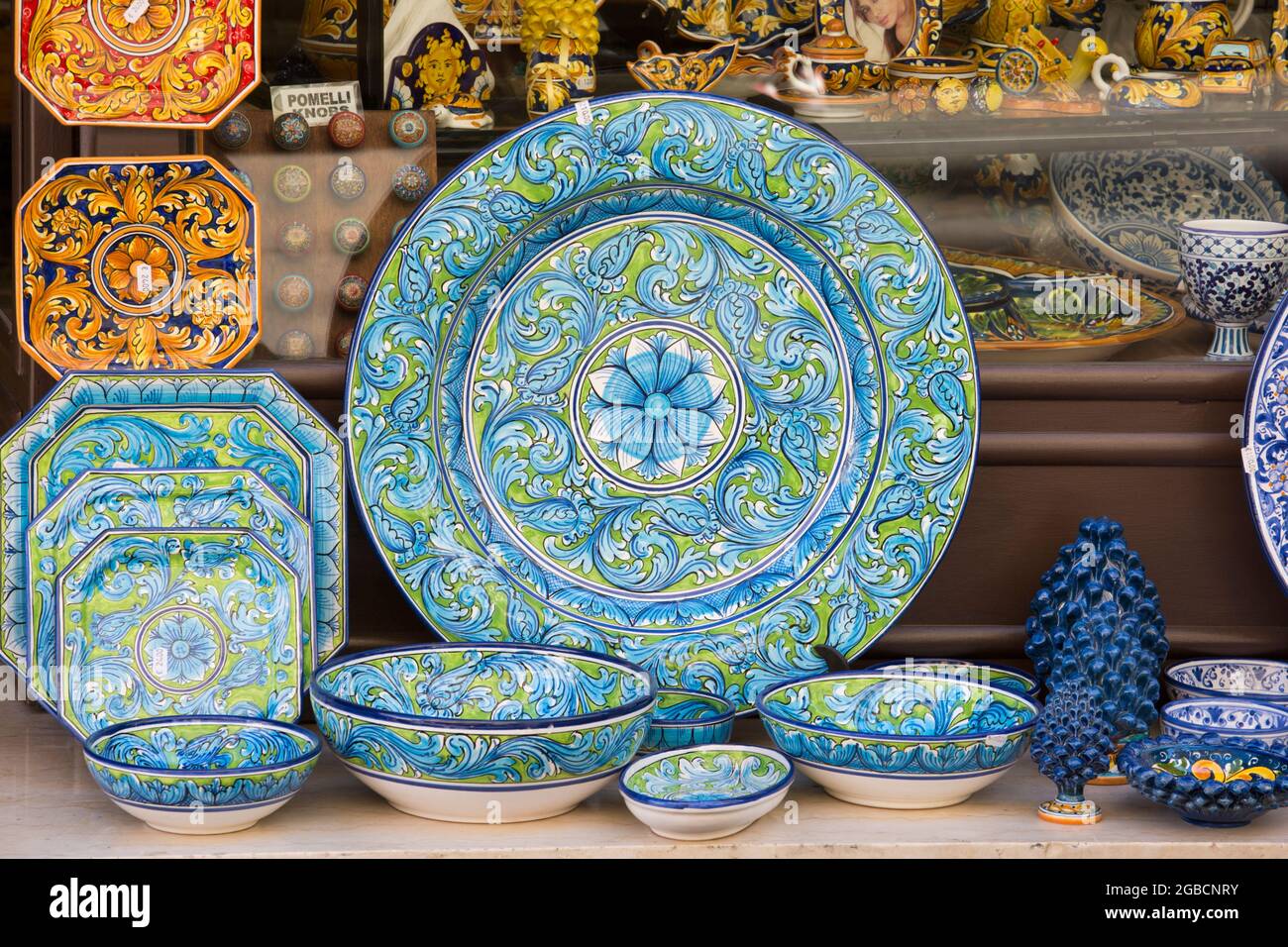 Taormina, Messina, Sicily, Italy. Eye-catching ceramic ware on display outside a typical souvenir and craft shop in Via Teatro Greco. Stock Photo