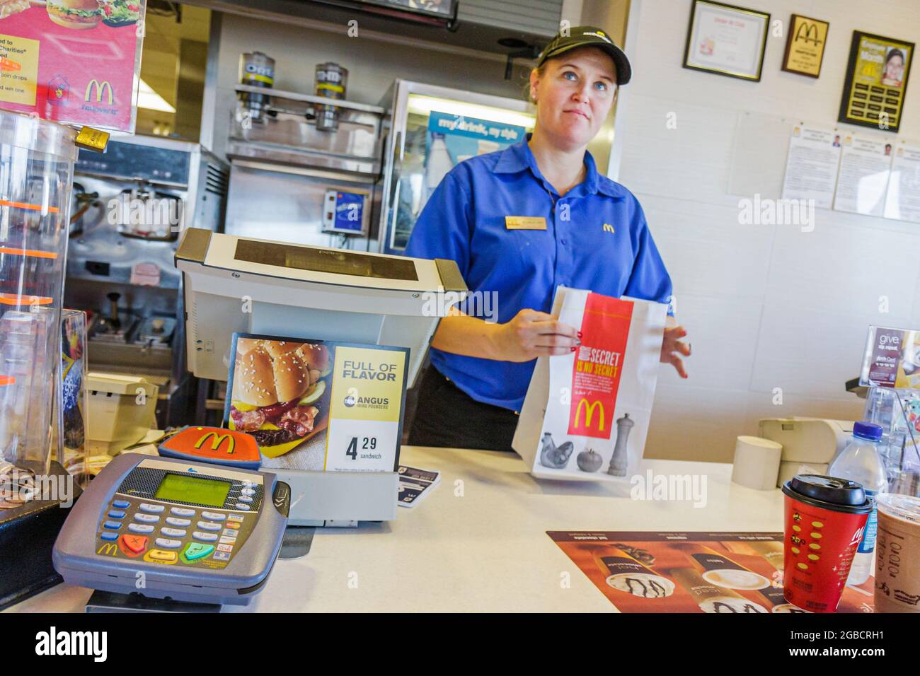 Georgia Newport McDonald's restaurant inside interior,fast food counter woman female cashier worker working employee bag Stock Photo