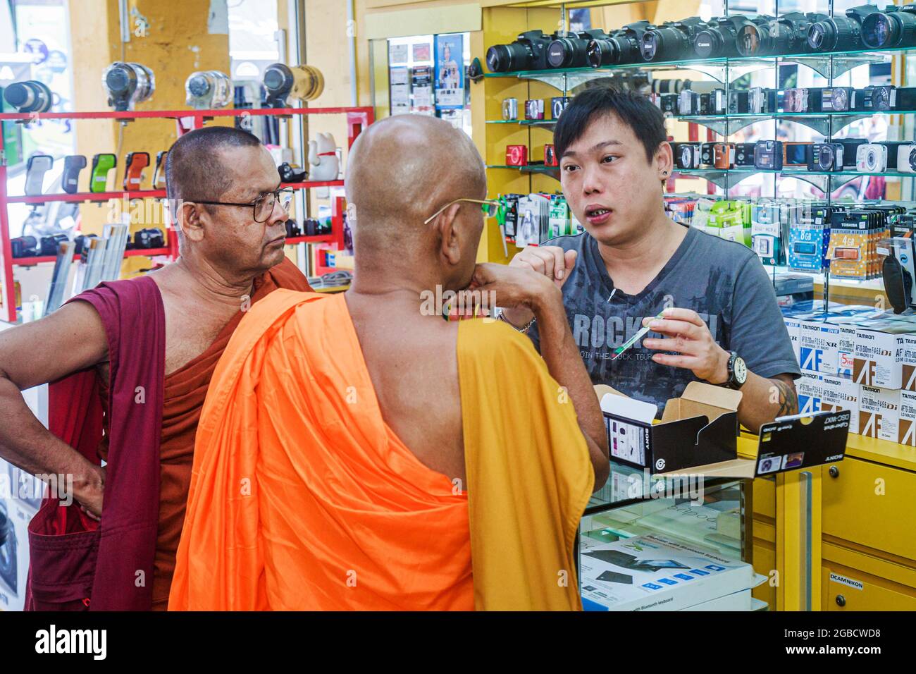 Singapore Little India electronics store camera cameras,Asian man employee counter salesman,Buddhist monk monks customers,shopping store inside interi Stock Photo
