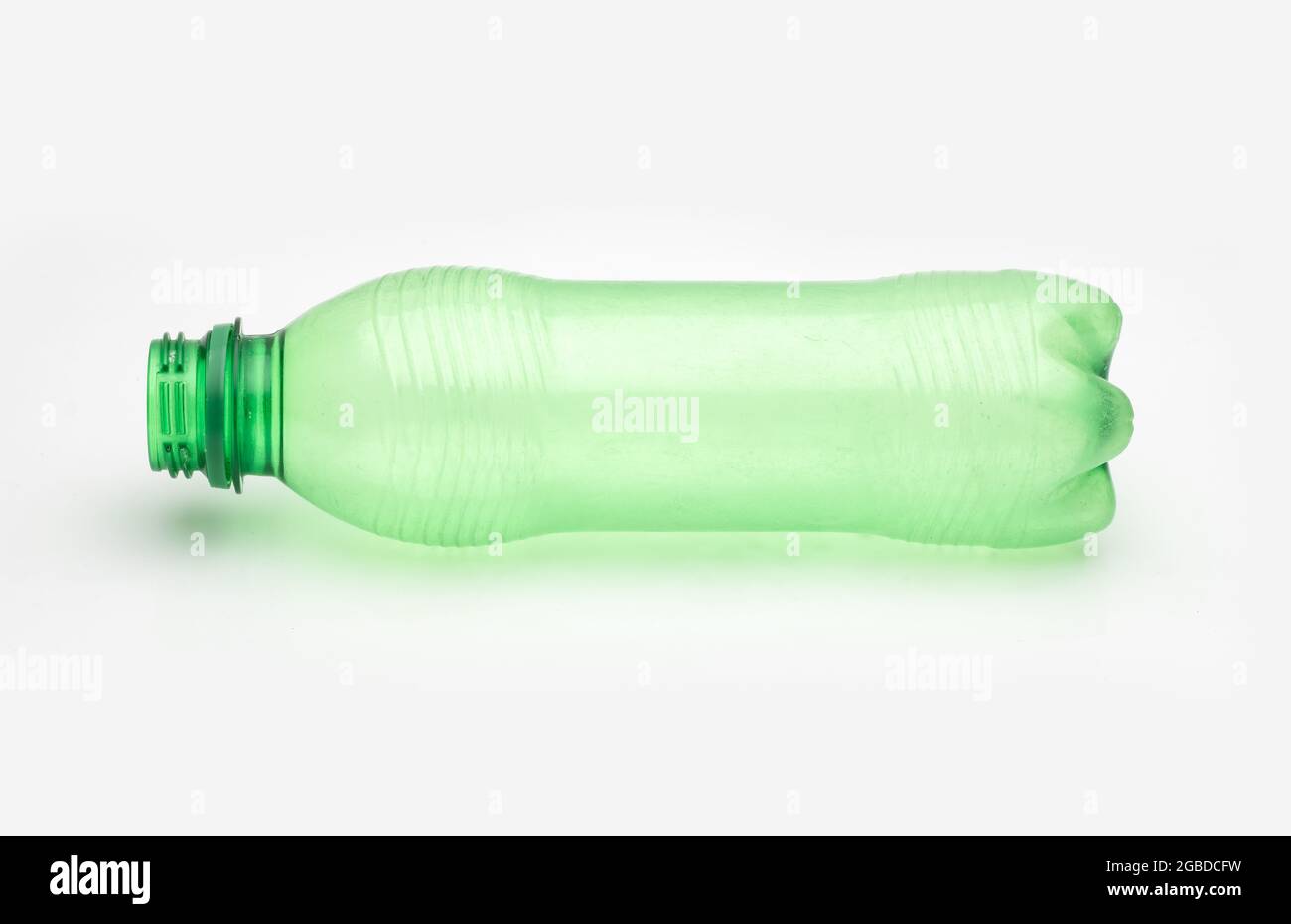 Used transparent green plastic bottle on an isolated white background Stock Photo