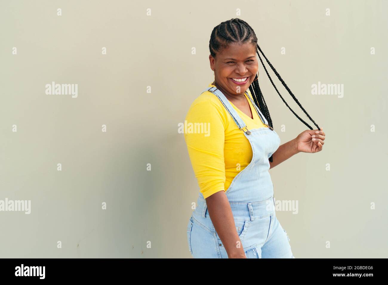 Mature black woman posing against the wall background Stock Photo - Alamy