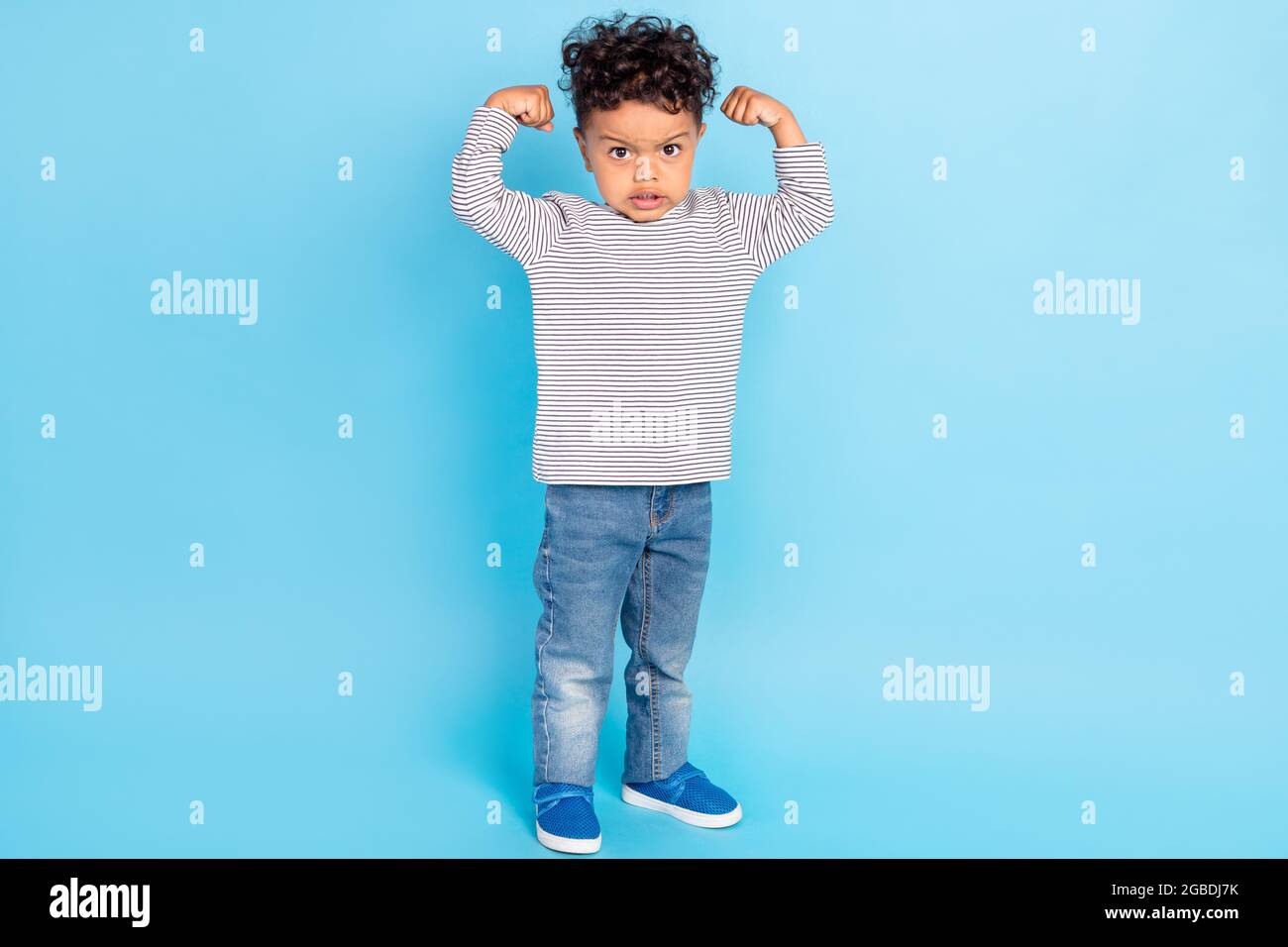 Full length body size view of attractive funny strong boy demonstrating