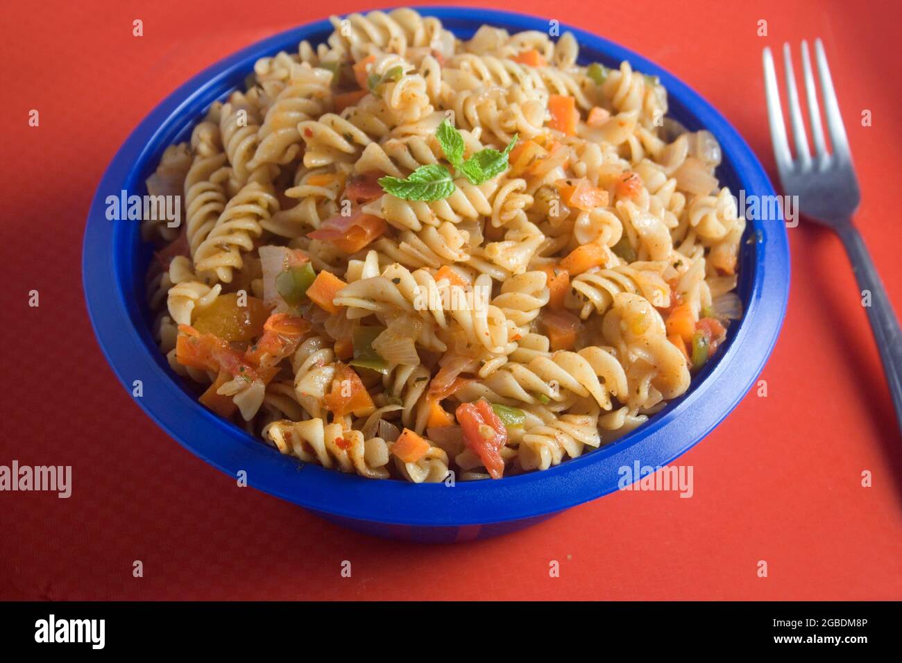 Bowl full of fresh homemade elbow macaroni pasta with sausage pieces