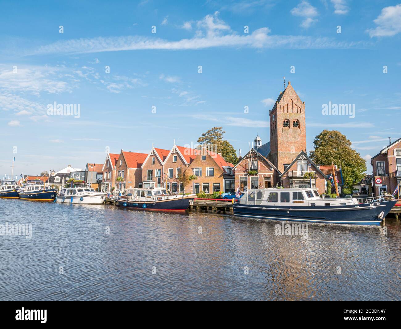 Boats, houses and church tower in old town of Grouw, Friesland, Netherlands Stock Photo
