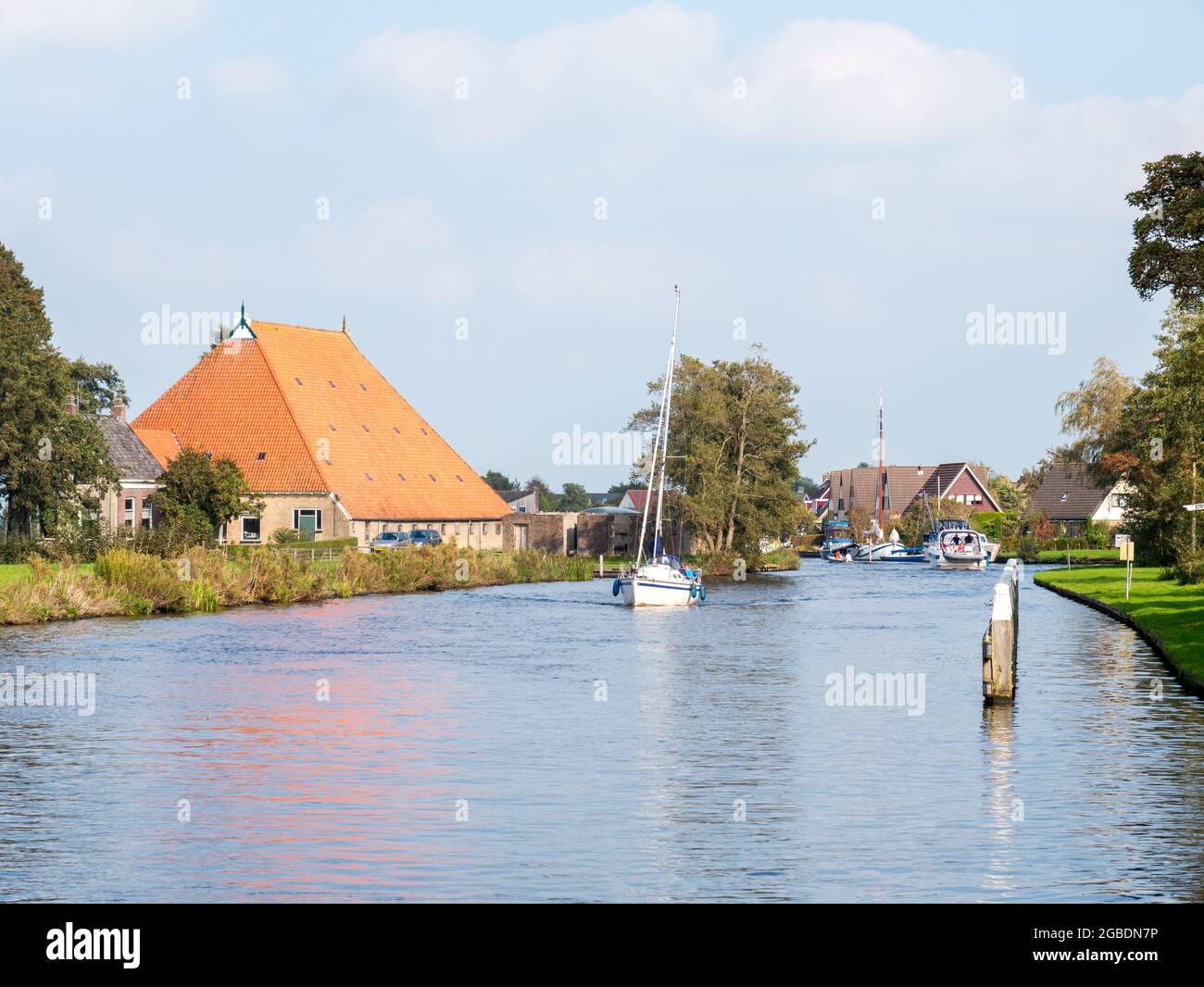 People on sailing boat cruising on river Boorne in Akkrum, Friesland, Netherlands Stock Photo