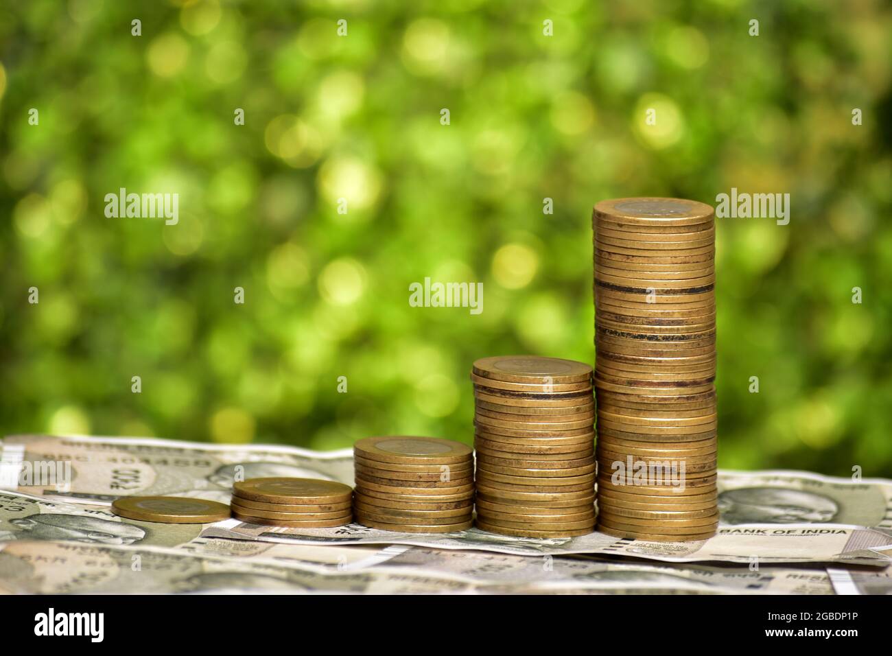 indian money concept, rupees coins stack on green blurred background ...