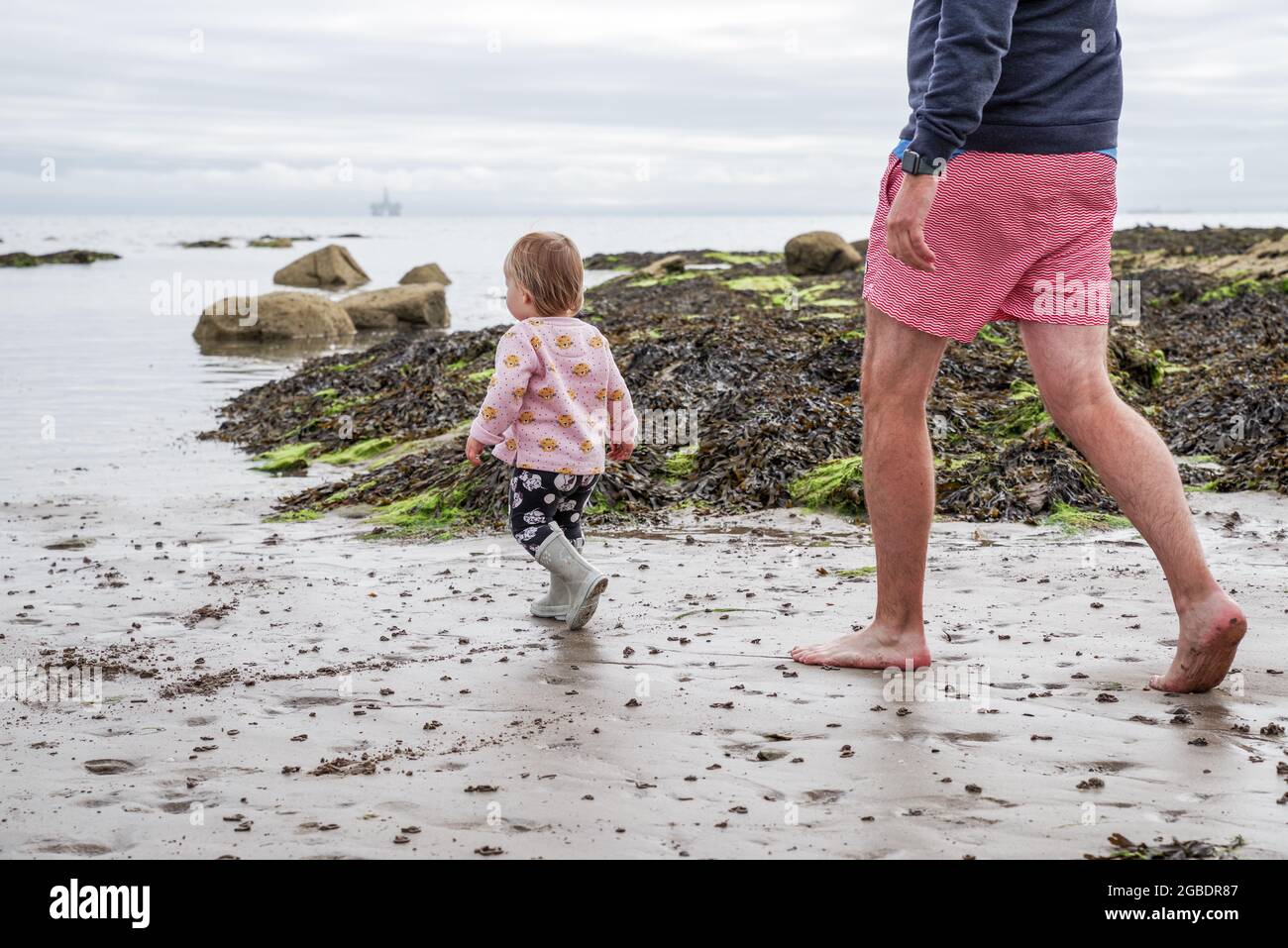 Dad and baby enjoying an outing to the beach on a UK domestic holiday - Fife, Scotland Stock Photo