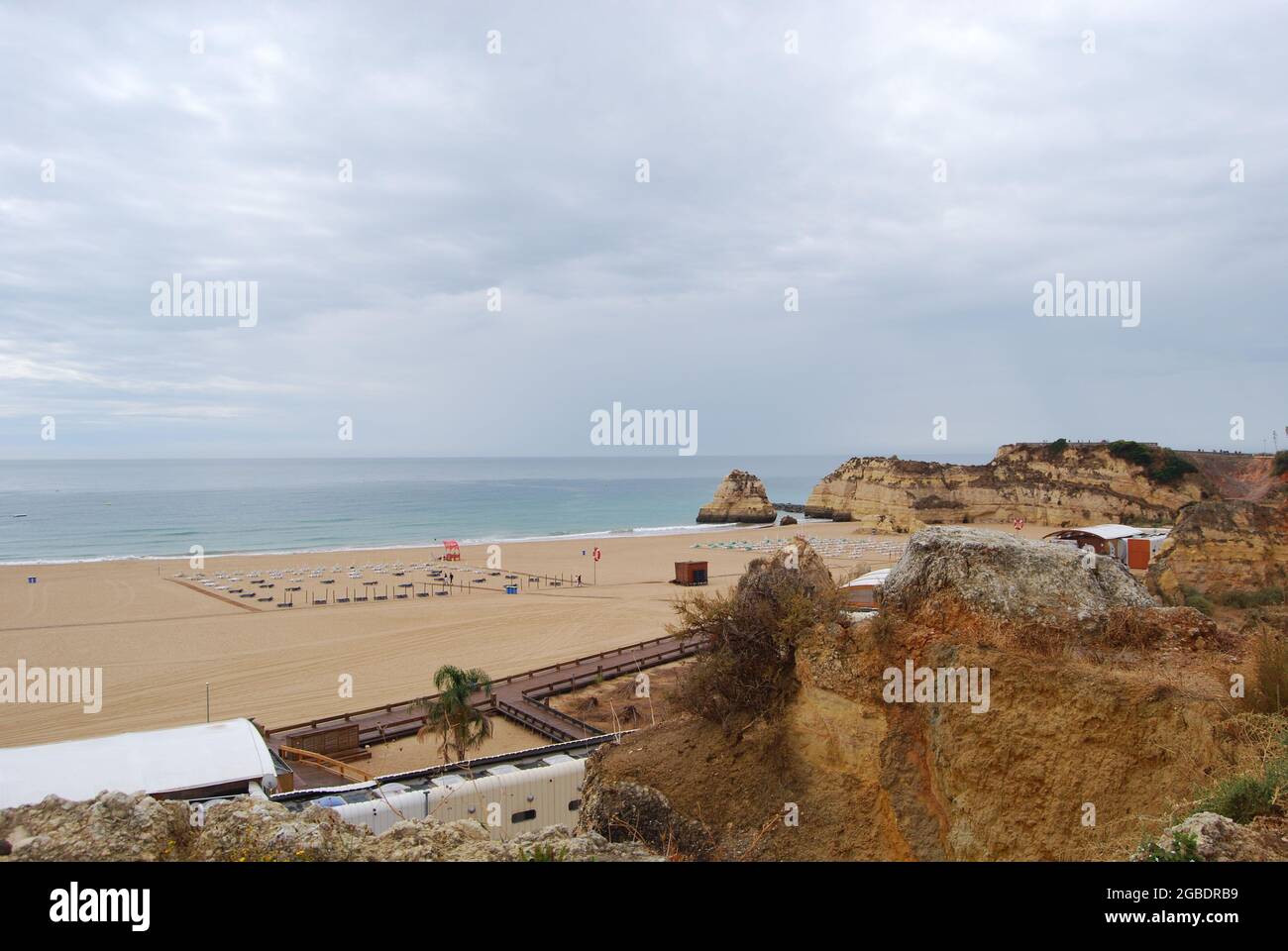 Landscape of a beach surrounded by cliffs and sea under a cloudy sky ...