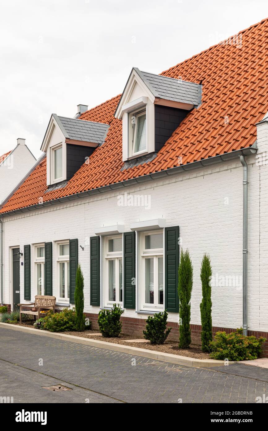 White modern houses with an orange roof in Thorn, Limburg, The
