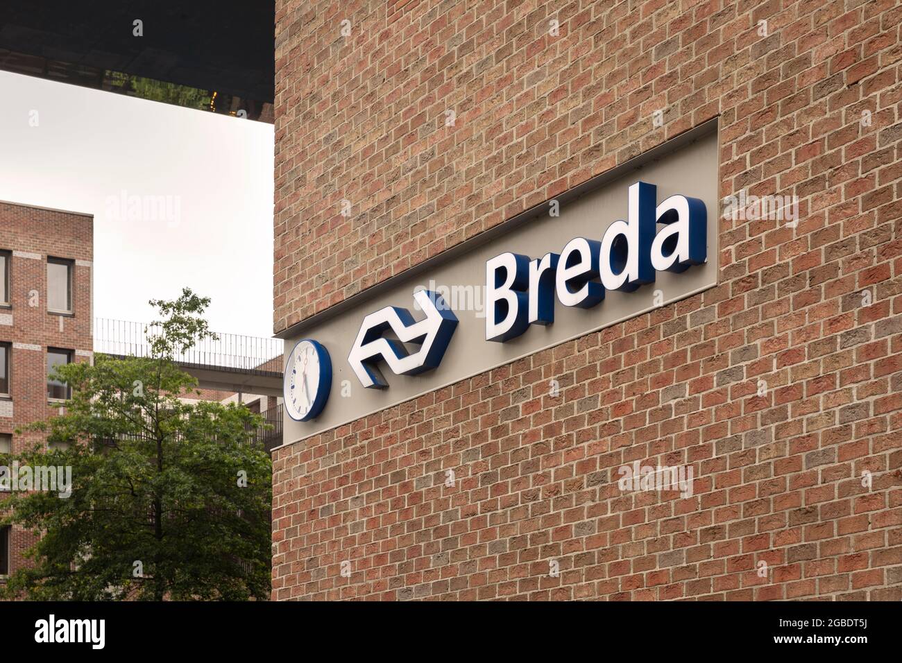 Breda, The Netherlands June 28th 2021. The central station of Breda, a dutch city in North Brabant, with a detail of the logo of NS and a clock on the Stock Photo