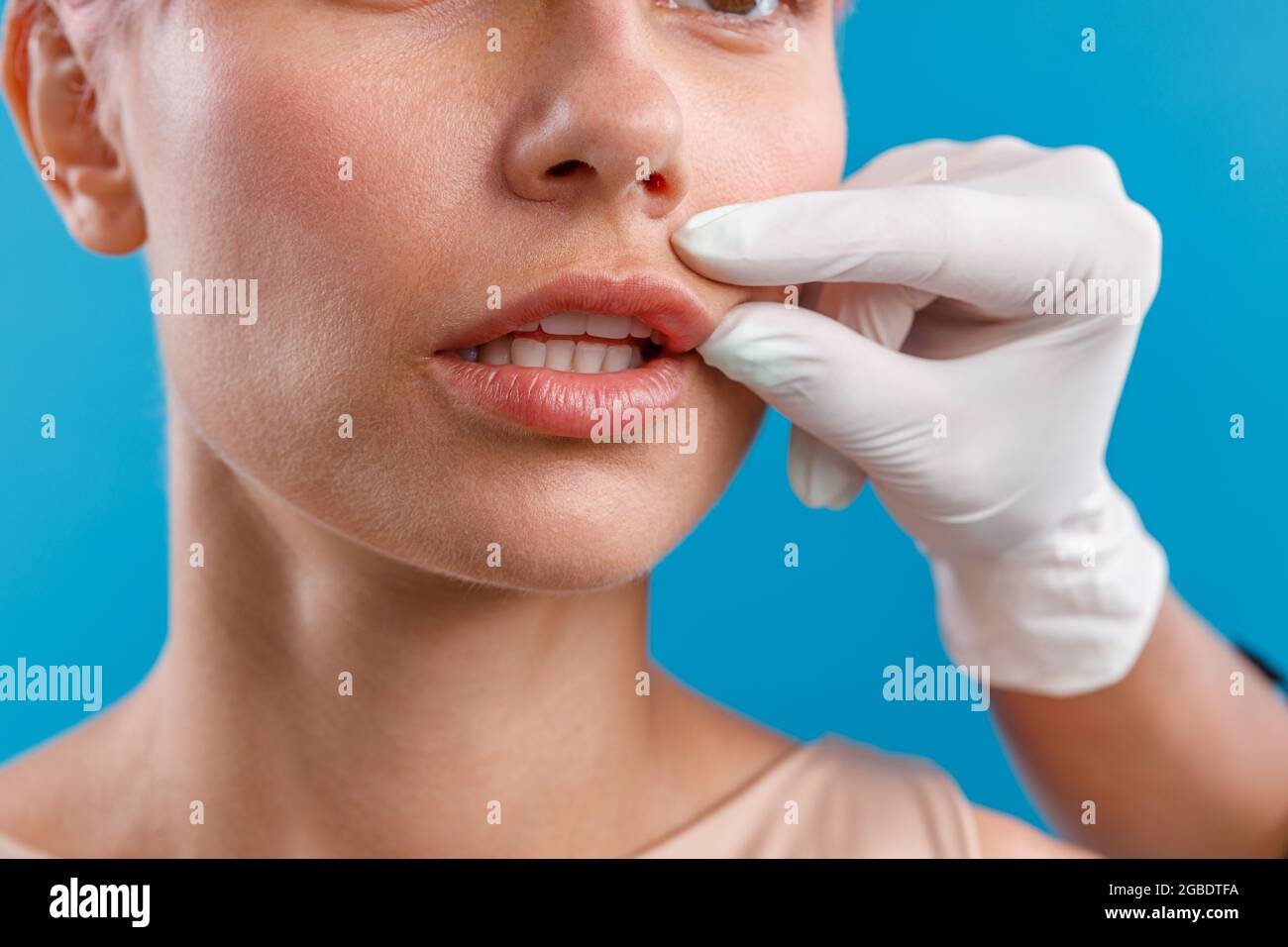 Hand of beautician touching female lips, examining face before giving botox injection Stock Photo