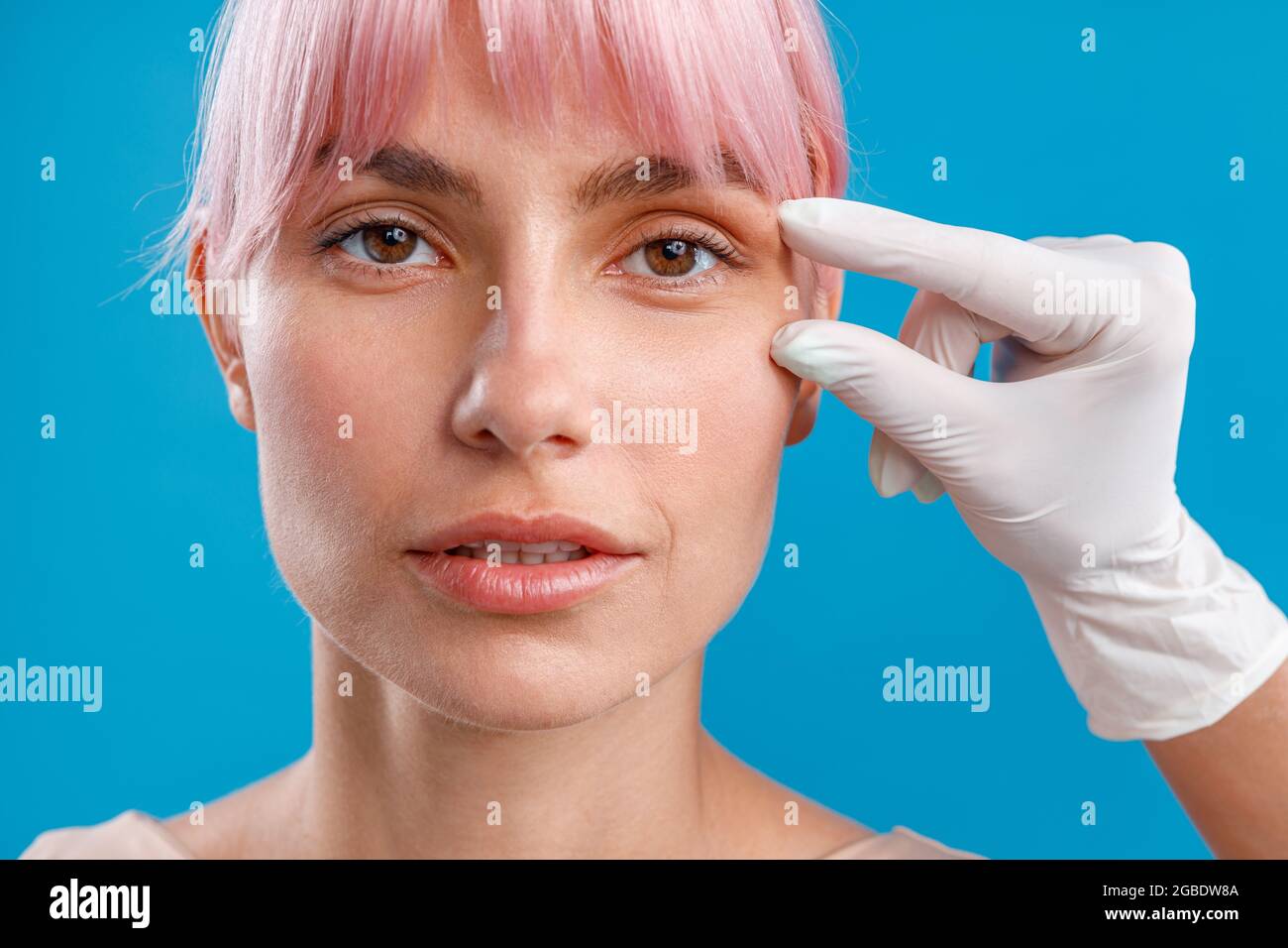 Hand of beautician touching female face, examining it before giving botox injection Stock Photo