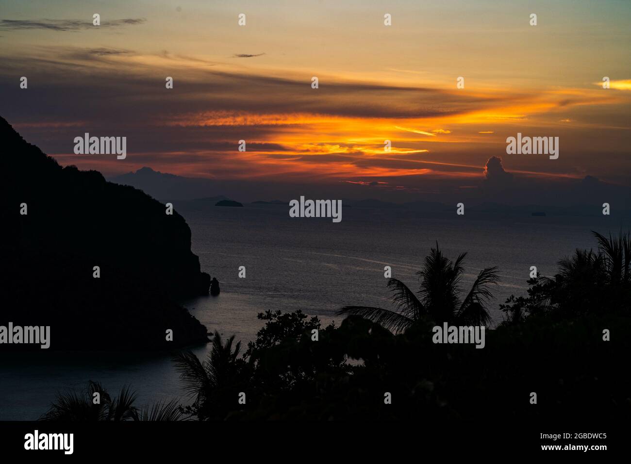 Mesmerizing view of sunset over silhouette mountains, trees red sky the ...