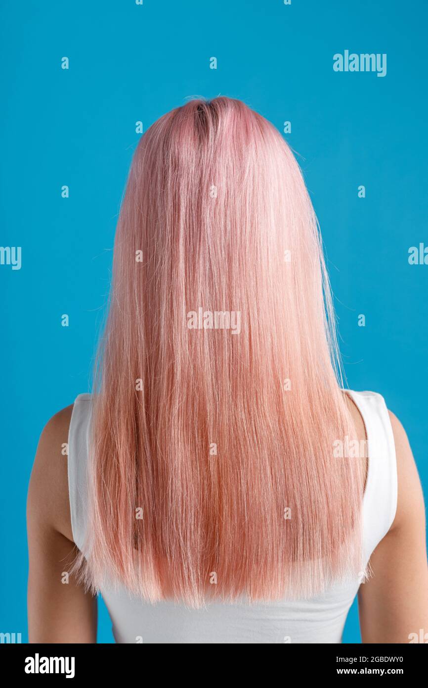 Beautiful Sleek Natural Long Pink Color Dyed Hair Of Young Woman Standing Isolated Over Blue Studio Background Stock Photo Alamy