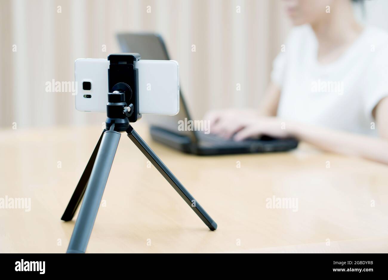 Woman vlogger looking using laptop computer and filming on video her life Stock Photo