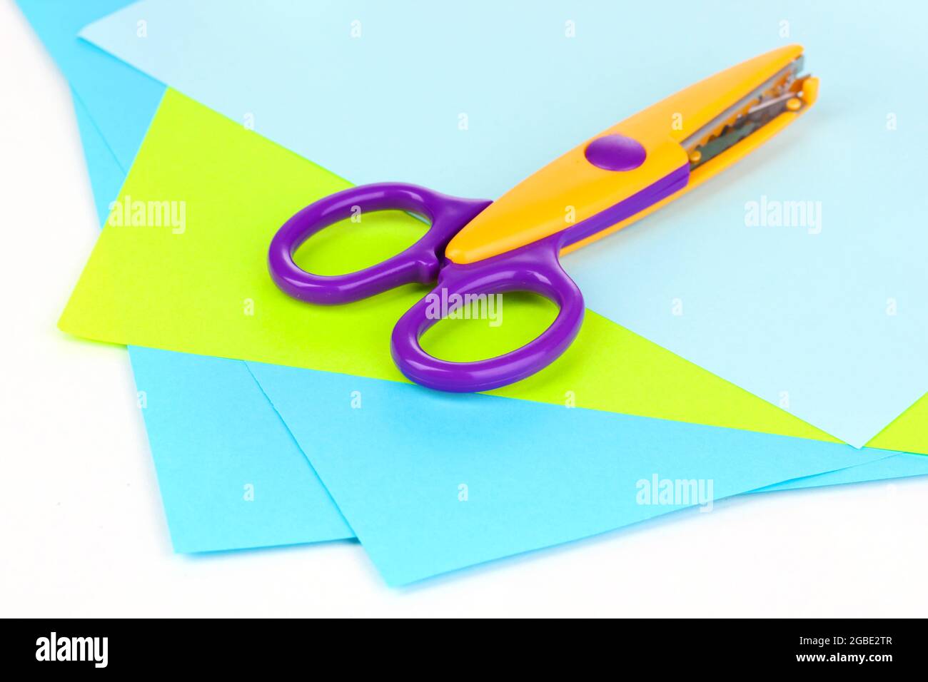 Colorful zigzag scissors with color paper isolated on white Stock Photo