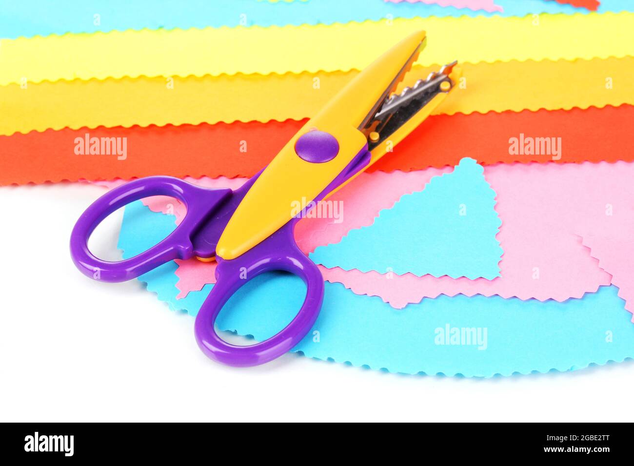 Colorful zigzag scissors with color paper isolated on white Stock Photo