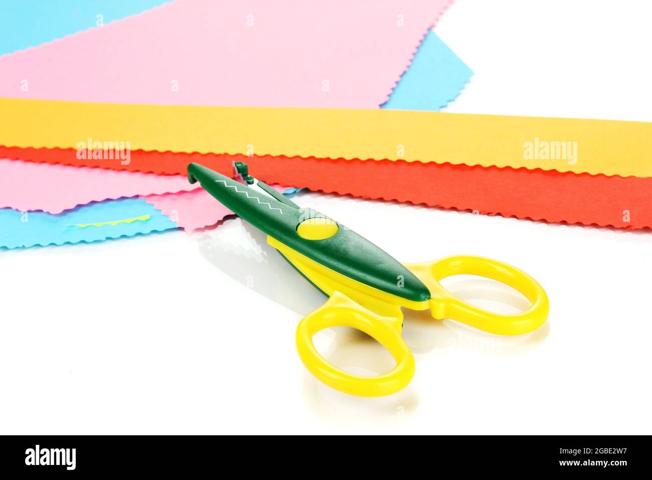 Colorful zigzag scissors with color paper isolated on white Stock Photo