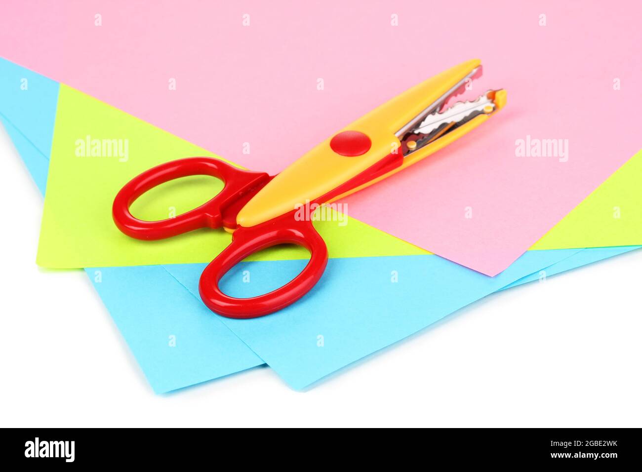 Colorful zigzag scissors with color paper isolated on white Stock Photo