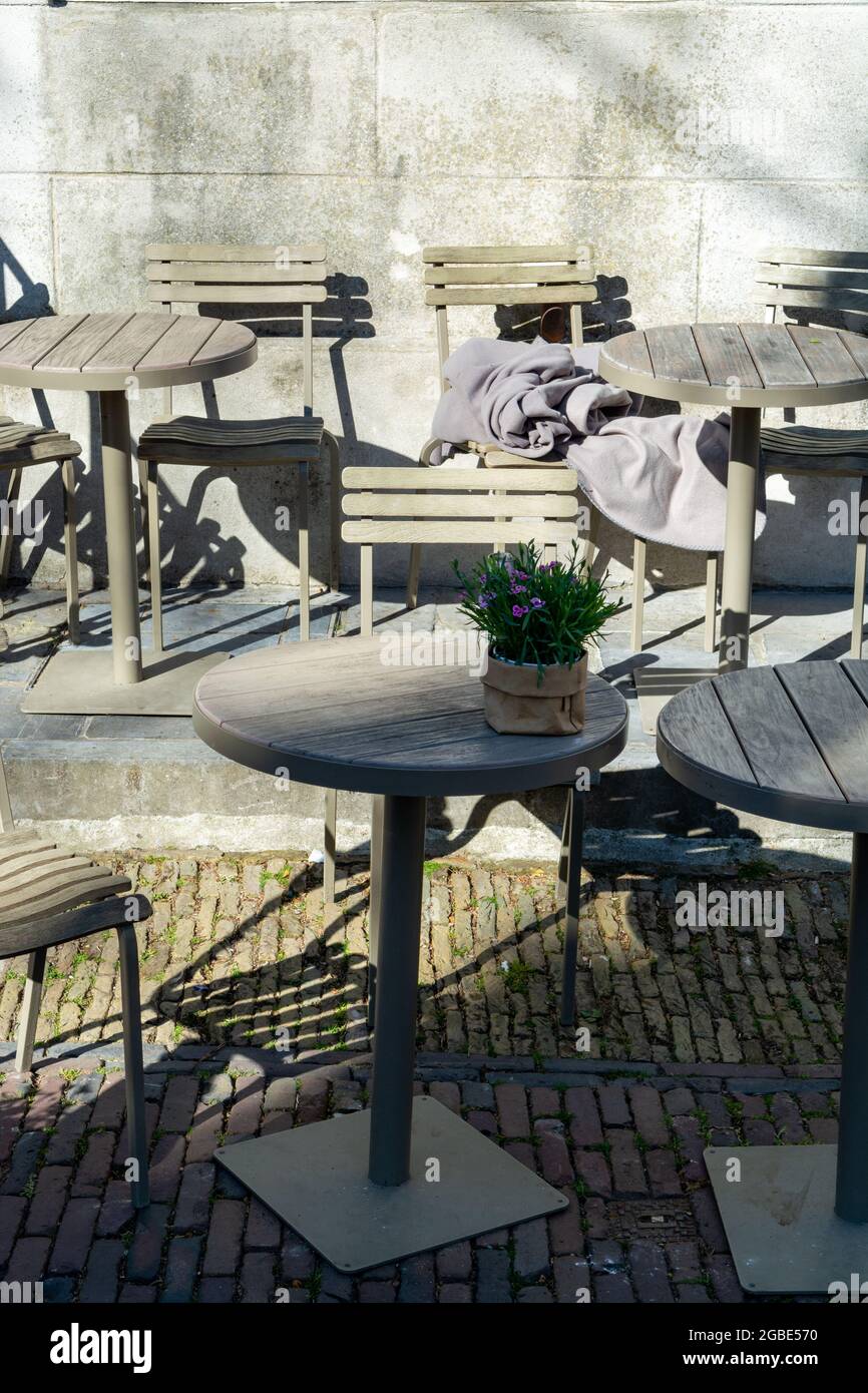 Vintage metal bistro table and chairs set in outdoor cafe, used for breakfast, lunch and dinner ...