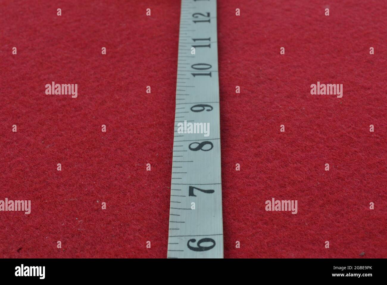 White tape measure on a red background with the numbers Stock Photo