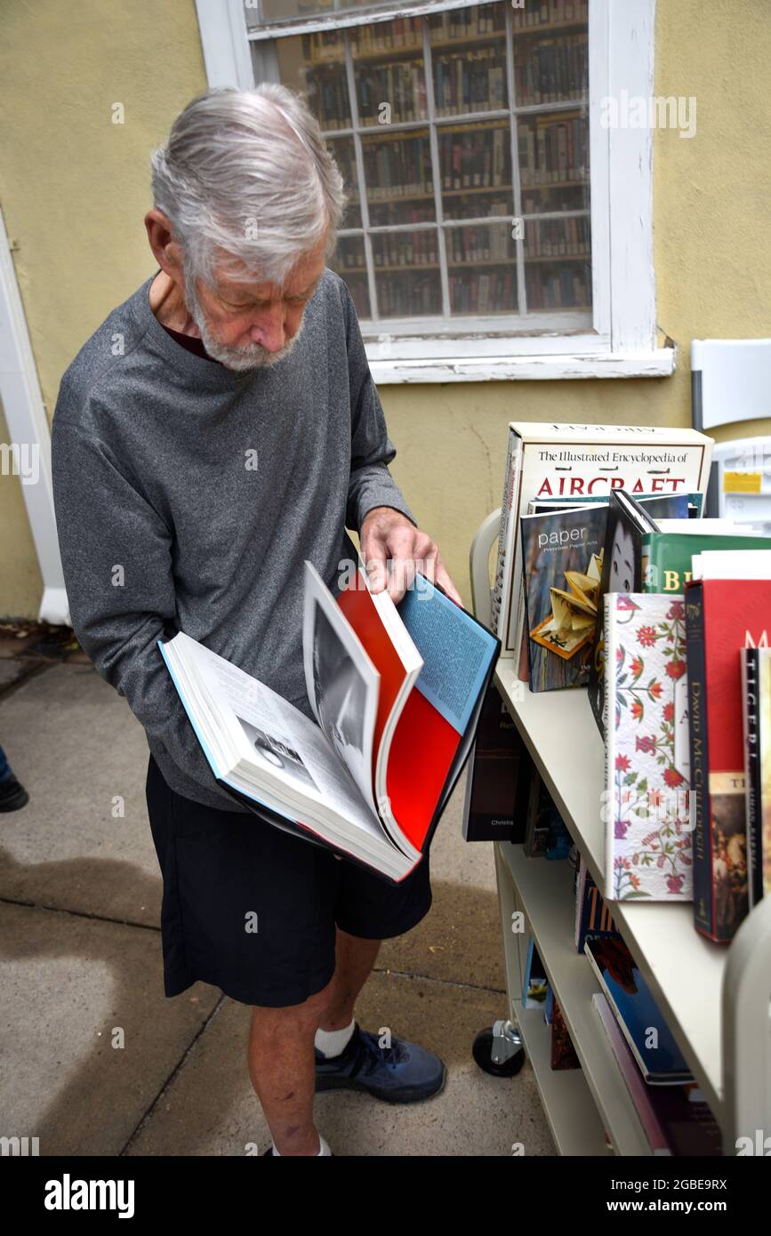 A man browses through a selection of books being sold by a public library in Santa Fe, New Mexico. Stock Photo