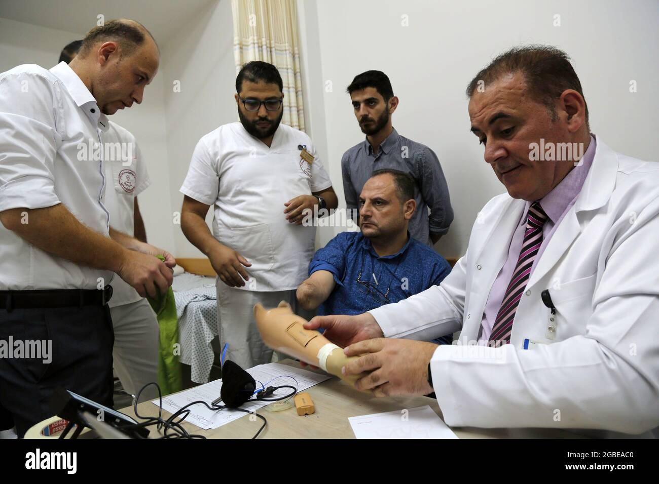 Gaza, Palestine. 03rd Aug, 2021. Palestinian doctors check a smart prosthetic hand before installation on a Palestinian amputee man in Gaza. Gaza strip has witnessed the first installation of a smart prosthetic hand for a Palestinian amputee man as a test at HH Sheikh Hamad Hospital for Rehabilitation and Prosthetics, funded by the Qatar Fund For Development (QFFD) as part of the Qatari support to the Palestinian Health sector. Credit: SOPA Images Limited/Alamy Live News Stock Photo